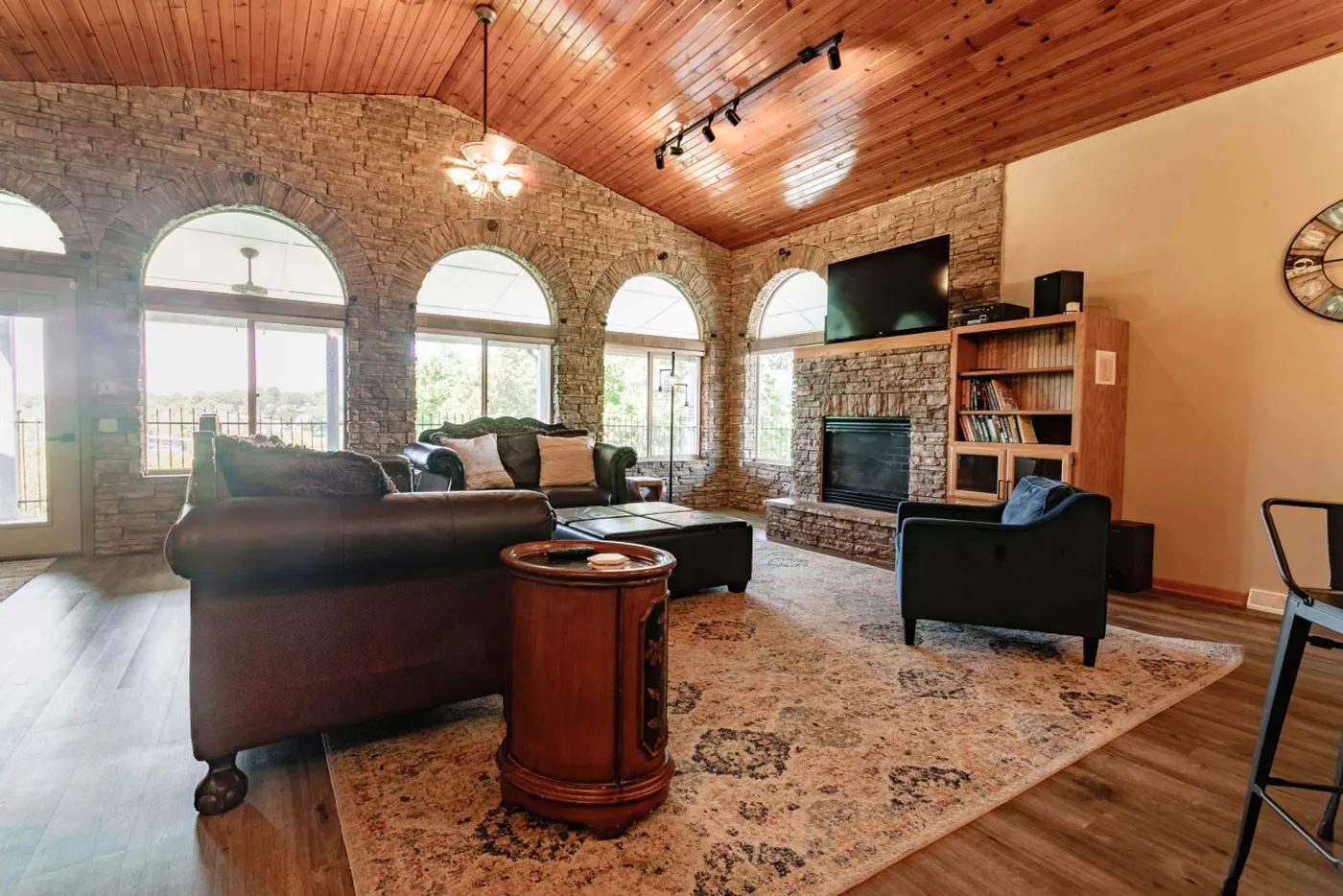 Great room with stone fireplace and vaulted wood ceiling